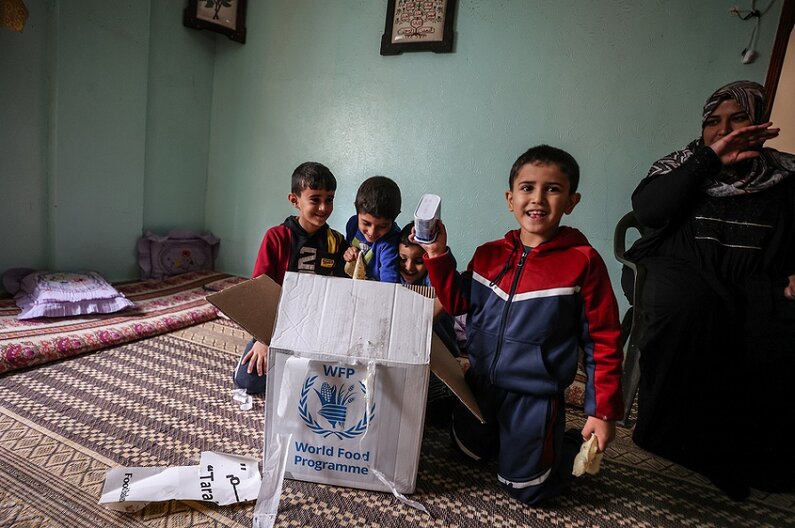 Khitam y su familia de 6 personas acaban de abrir un paquete de alimentos proporcionado por el Programa Mundial de Alientos. © WFP/Ali Jadallah 