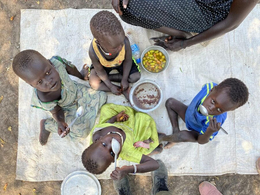 Sudán del Sur: Niños en Akobo Este, Jonglei, comen su almuerzo de sorgo con una fruta local — la última vez que se declaró una hambruna en el país fue en el 2017. Foto: WFP/Marwa Awad