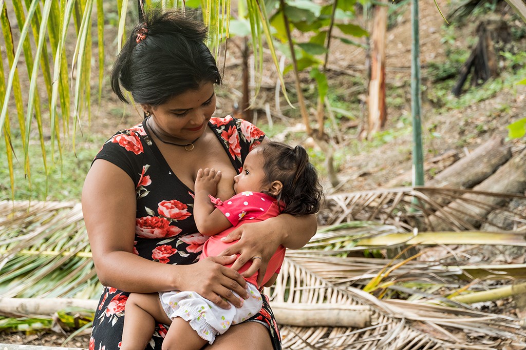 Una mujer amamanta a su bebé luego de recibir su bono del WFP en Ecuador
