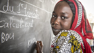 Kaka Marabou escribe su nombre en la pizarra de la escuela en Yakoua, Lago Chad. Los refugiados, las personas desplazadas y otras comunidades pobres de la cuenca del lago Chad dependen de la asistencia humanitaria para sobrevivir y el acceso a la educación básica también es limitado. WFP/Giulio d'Adamo