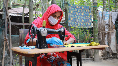 Durante la pandemia de la Covid-19, en Cox's Bazar, Bangladesh, el WFP trabajó con mujeres de la comunidad de acogida y refugiados rohingya a través de su programa de medios de vida para fabricar barbijos o mascarillas que fueron distribuidas por el gobierno local y las agencias humanitarias, otorgándoles un estipendio mensual, capacitación laboral comercializable y educación financiera y una beca para iniciar un negocio. WFP/Nalifa Mehelin