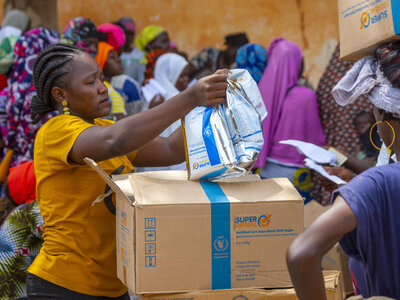 Woman distributes corn-soya blend in a IDP camp in Burkina Faso. Foto: WFP/Cheick Omar Bandaogo