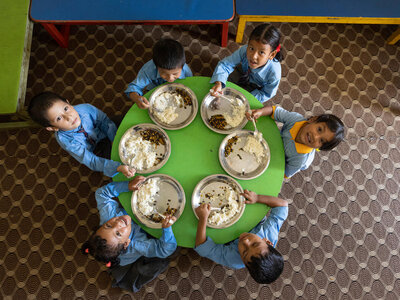Un grupo de escolares está tomando el almuerzo del colegio.