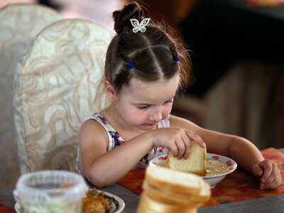 Joven refugiada ucraniana tomando su comida caliente en la cantina de un Centro de Alojamiento para Refugiados en Chisinau, Moldavia.