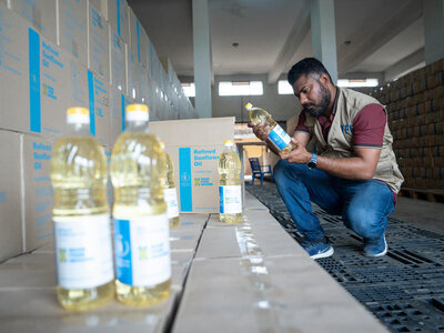 WFP/Saikat Mojumder Un empleado del WFP inspecciona las cajas de aceite de girasol compradas para las cestas de asistencia alimentaria del WFP.