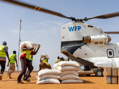 Personal descargando sacos de asistencia alimentaria de un helicóptero de gran capacidad del WFP