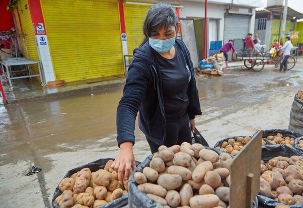 Keyla del Valle, migrante venezolana, compra papas en el mercado callejero. 