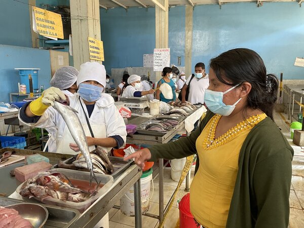 Angélica compra pescado fresco en el mercado local de Sechura, Perú