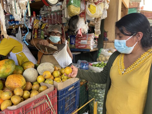 Angélica compra frutas citricas en el mercado de Sechura, Perú
