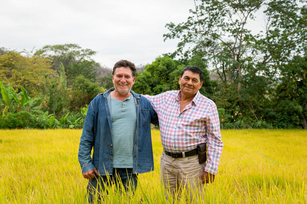 Marcelo Granda (izquierda) y su amigo Luis Carpio en el arrozal de Marcelo