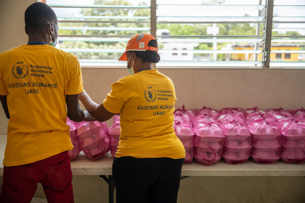Dos miembros del personal del WFP empacan las comidas