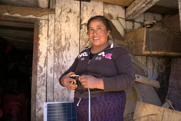 Rosenda García trabaja con algunos cables de electricidad en el exterior de una casa.