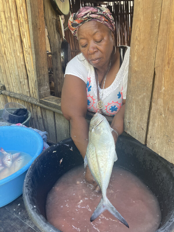 Mujer garífuna limpia el pescado