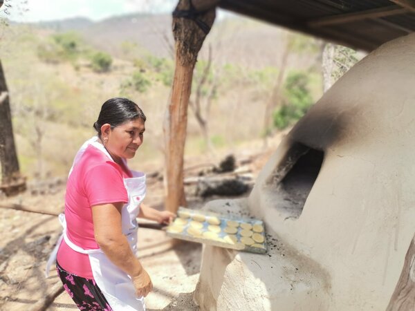 La señora María Corea se prepara para meter el pan al horno.