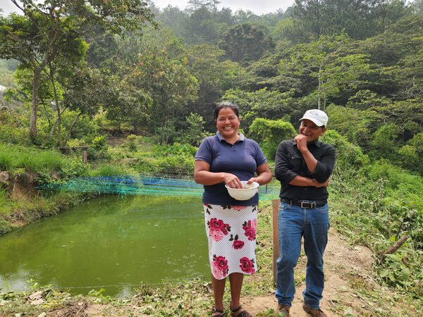 Los esposos Isabel Manueles y Jobel Gómez frente a uno de sus cuatro estanques de tilapia. 