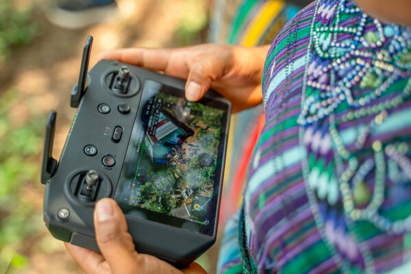 Dos manos sostienen el control del dron con pantalla integrada