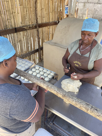 Yolanda Martínez y una socia preparan las bolitas de masa de pan de coco para luego moldearlo.
