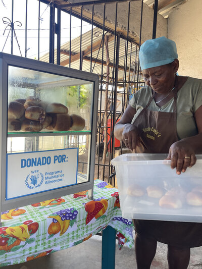 Yolanda coloca el pan en una vitrina para la venta.