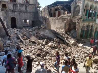 A photo shows damaged buildings as people inspect after a 7.2 magnitude earthquake