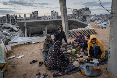 Abu Omar y su familia comen un iftar de Ramadán entre las ruinas de su hogar.