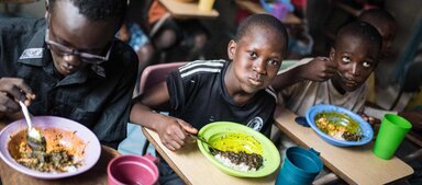 Huérfanos, cuyos padres murieron durante el brote de ébola en Sierra Leona, comen un almuerzo preparado con alimentos proporcionados por WFP en Freetown, Sierra Leona. Foto: WFP/Jordan Sissons