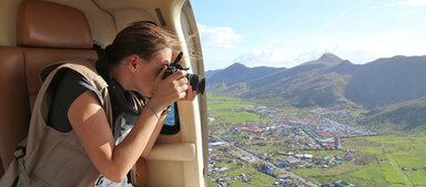 Mujer tomando fotos desde el helicóptero