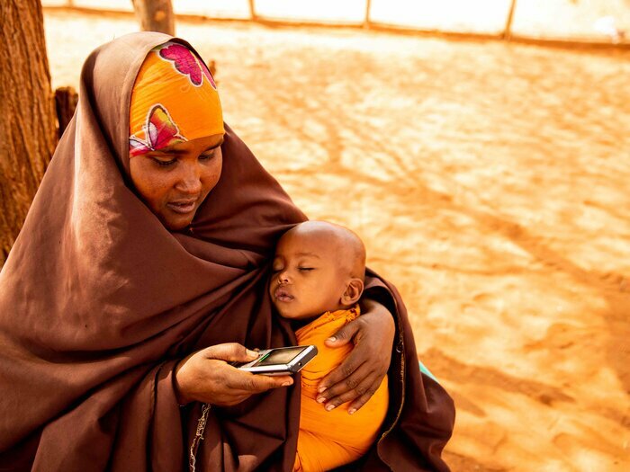 Mujer con bebé hace usa un celular