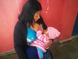 Flora amamanta a la pequeña Angélica mientras espera su turno para retirar su transferencia de efectivo. Foto: WFP/Hetze Tosta