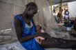 A woman with a blue dress cradles a tiny baby at a health clinic in South Sudan. Photo: WFP/Gabriela Vivacqua