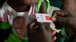 A closeup of a tape measuring malnutrition on the upper arm of a child, and showing red - the sign of severe-acute malnutrition. Photo: WFP/Gabriela Vivacqua