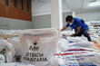 Un miembro del personal de WFP prepara cestas de alimentos para distribuirlas entre los hogares afectados por el terremoto