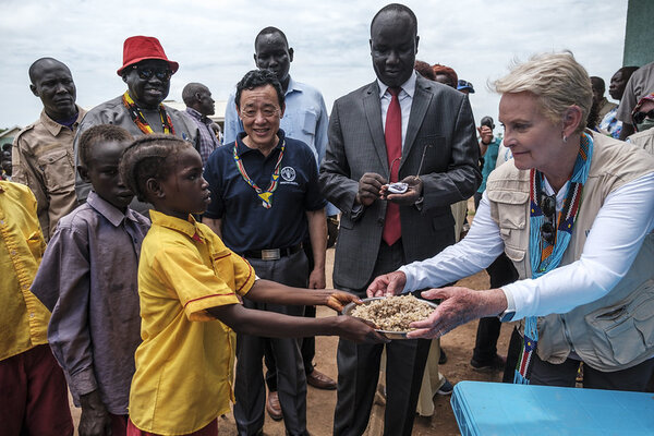 FAO/FIDA/WFP/Eduardo Soteras. Aweil, Sudán del Sur -  La Directora Ejecutiva del WFP, Cindy McCain (derecha), entrega un plato de comida a un estudiante durante una visita a la escuela primaria de Udhaba, en el pueblo de Udhaba, como parte de la visita oficial de los directores de las agencias con sede en Roma a Sudán del Sur.