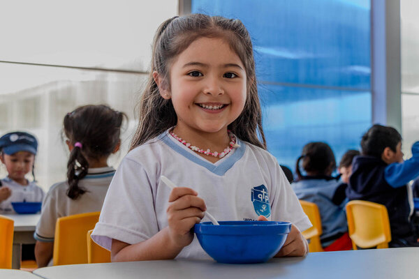Amara Alulema disfrutando su almuerzo escolar en la cafetería de la Institución Pérez Pallares en Quito.