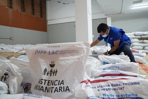 Un miembro del personal de WFP prepara cestas de alimentos para distribuirlas entre los hogares afectados por el terremoto