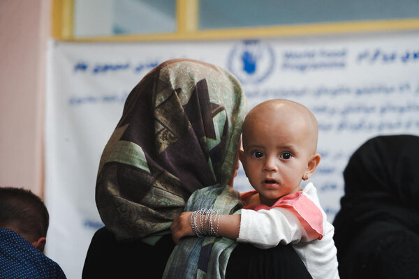 Foto: WFP/Mohammad Hasib Hazinyar. Una madre con su hija llega a la clínica de Bagrami, que cuenta con el apoyo de WFP en actividades contra la desnutrición. Ha traído a su hija desnutrida para recibir el apoyo de WFP y suplementos nutricionales. Kabul, Afganistán.