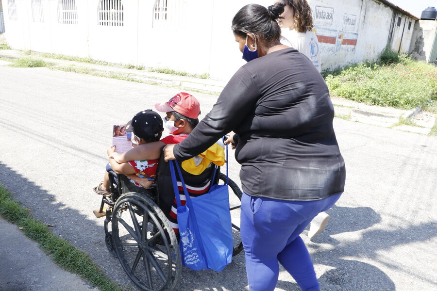 Yolabel empuja la silla de ruedas en que lleva a sus hijos Omar y Richard.