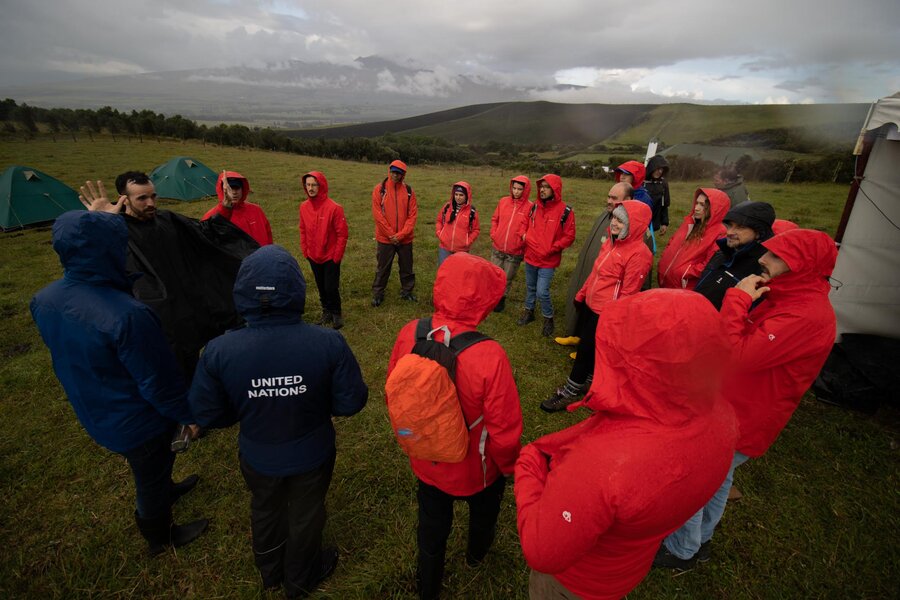 Un grupo de personas con abrigos rojos escuchan las instrucciones antes de una simulación.