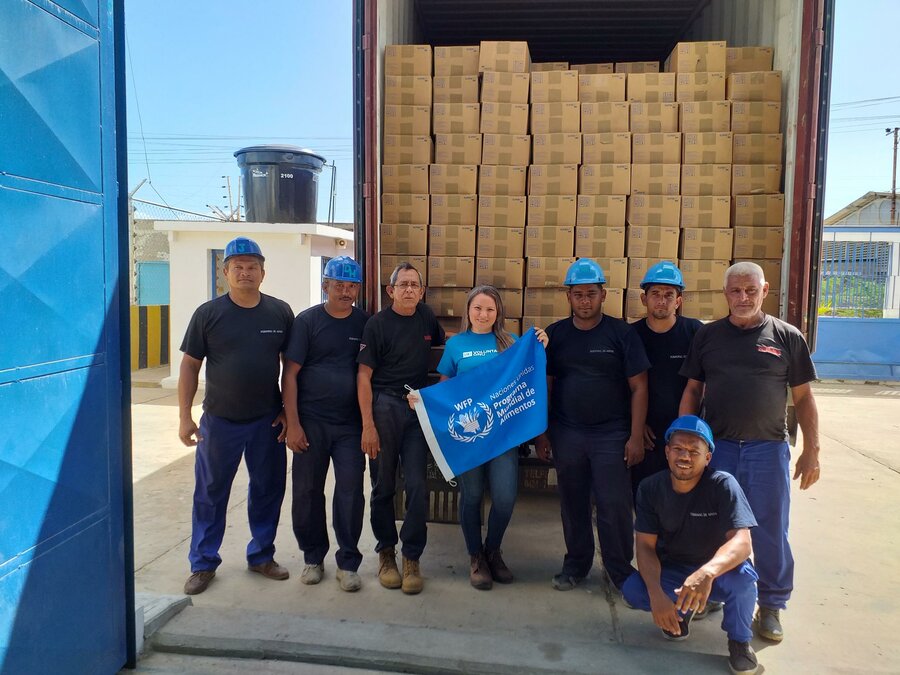 Empleada de WFP con una bandera de WFP y 7 trabajadores