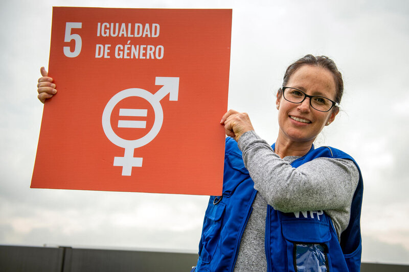Carmen Guevara, oficial de género en el Programa Mundial de Alimentos en Ecuador, sostiene un afiche sobre el Objetivo de Desarrollo Sostenible 5.