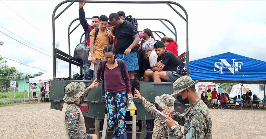 Migrantes que atravesaron el tapón del Darién son registrados por agentes del Servicio Nacional de Fronteras (SENAFRONT) a su llegada a una estación de recepción de migrantes en Metetí, Panamá.