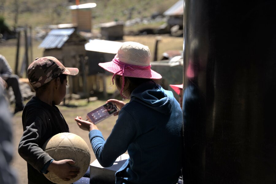 Una mujer técnica en la instalación de paneles solares muestra un niño uno de sus instrumentos. 