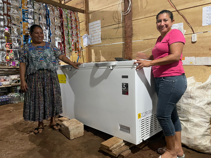 Las mujeres muestran una nevera recién comprada.