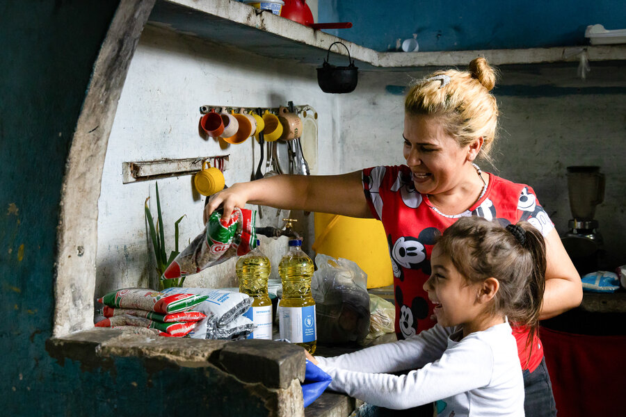 Frangil Caceres y su hija, Charlotte, desempacan las comidas escolares que WFP distribuye en Barinas, Venezuela. Foto: WFP/Marianela Gonzalez