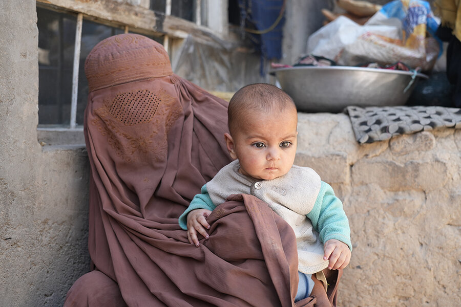 Woman holds baby in Kabul City settlement in Afghanistan
