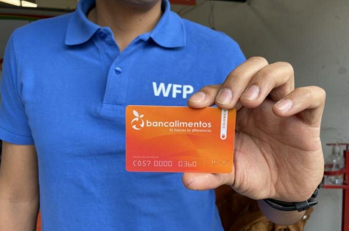 Funcionario de WFP muestra una tarjeta de Bancalimentos