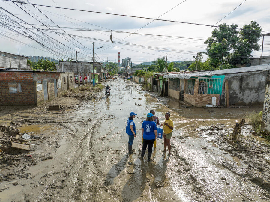 Toma de un dron del personal de WFP en Ecuador que conversan con lugareños en una calle afectada por las inundaciones. 