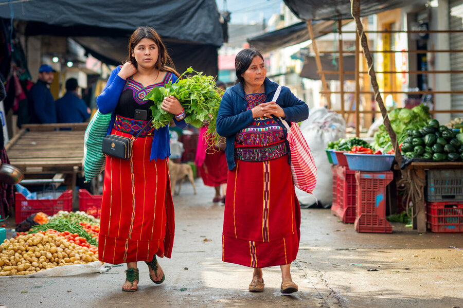 Maria y su hija Petronila caminan por un mercado público en Guatemala mientras compras alimentos. 