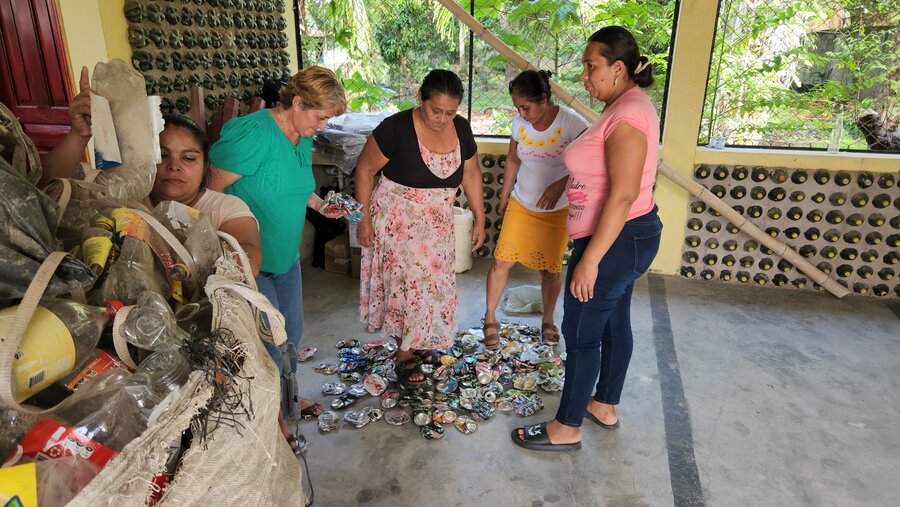 El grupo de reciclaje 6Rs aplastan algunas latas.