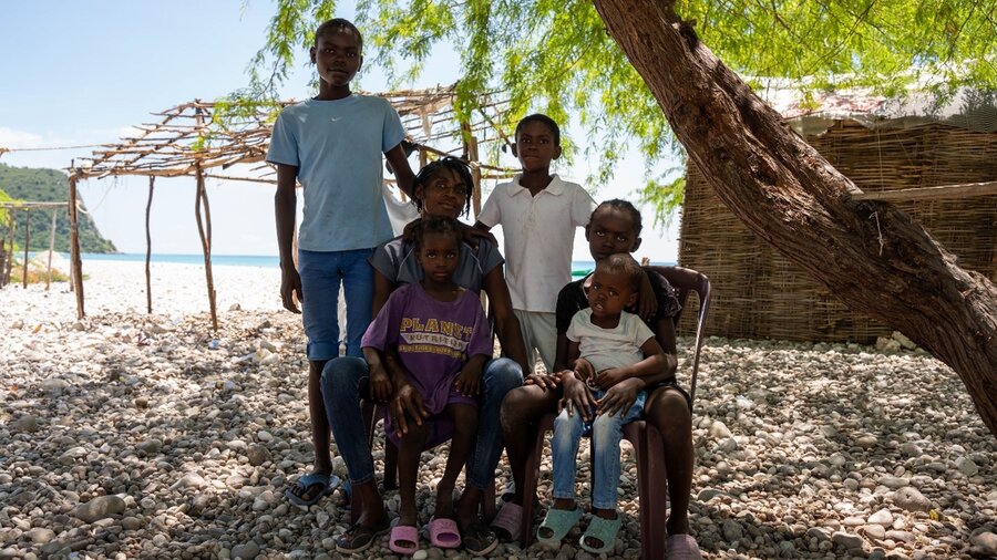 Nona posa con sus hijos bajo un árbol detrás de su pequeña choza. La asistencia que recibió la está ayudando a diversificar la dieta de sus hijos. Sureste de Haití. ©WFP/Pedro Rodrigues