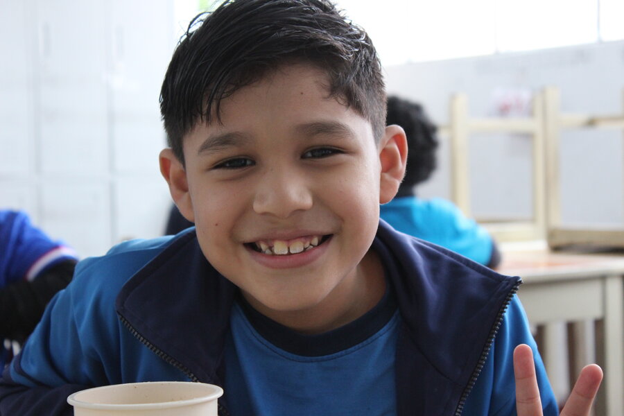 Loan Valentino Ulloa Cuellar de 3er grado, recibe una comida caliente en su escuela. Foto: WFP / Cristina Arakaki